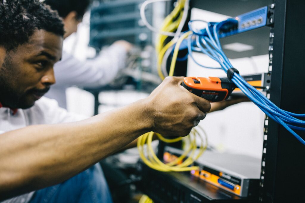 Network wiring technician installing a server rack
