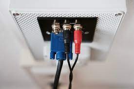 Two red and blue cables connected to a white box. Audio cable video, music.